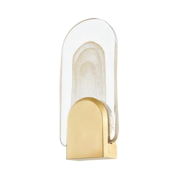 The Morganite LED sconce combines modern efficiency with artisanal craftsmanship. Its clear cast glass filled with organic bubbles creates a warm, distinctive glow, while the vintage brass bracket adds timeless elegance. Each piece is unique due to hand-applied gold dusting.