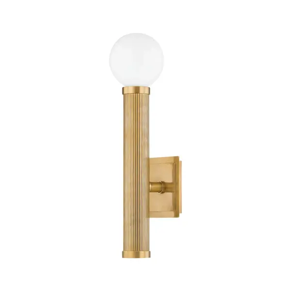 The Pienza wall sconce masterfully blends industrial minimalism with old Hollywood glamor. Its balanced design features dual glass orbs suspended on a vintage brass tube, creating a striking focal point that works equally well in modern and transitional spaces.