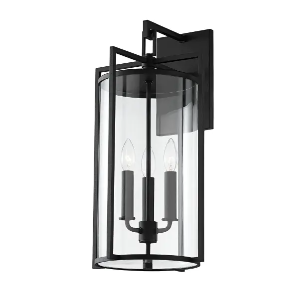 The Percy wall sconce blends classic craftsman details with transitional appeal. Sharp geometric angles frame a clear glass cylinder, creating visual interest while the textured black finish adds durability and sophistication for outdoor spaces.