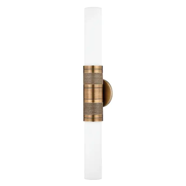 The Liam sconce elevates a classic tube design with layered detailing—machine-detailed brass bands and organic grass cloth create visual interest while opal glass provides soft, even illumination. Versatile mounting options make it adaptable.