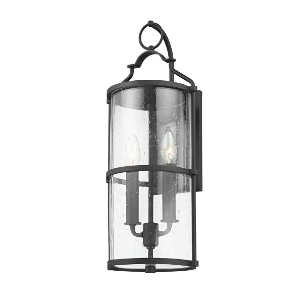 The Burbank wall sconce brings old-world charm to outdoor spaces with its decorative steeple-inspired handle and clear seeded glass. The textured black aluminum frame offers durability and wet-rated protection for exposed locations.