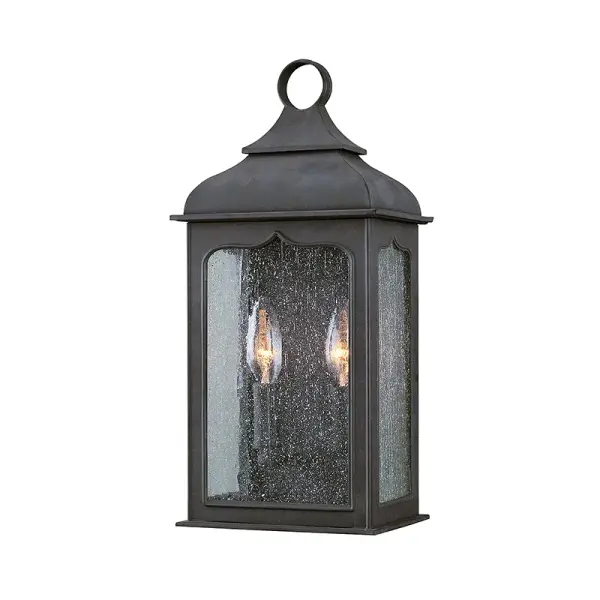 The Henry Street pocket lantern combines traditional styling with hand-forged iron construction and clear seeded glass. Its compact 7.25" width and wet-rated certification make it ideal for covered porches and entryways.