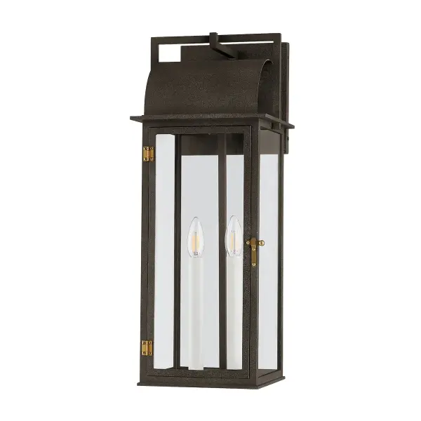 The Bohen wall sconce reimagines early American gas lanterns with clean lines and rustic elegance. Its French Iron finish with Patina Brass accents brings timeless character to traditional homes while providing reliable outdoor illumination.