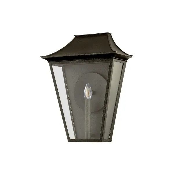 The Tehama wall sconce combines architectural design with functional illumination. Its reflector-enhanced candle design and clear glass panels maximize light output, while the angular frame and distinctive roof edges create visual interest.