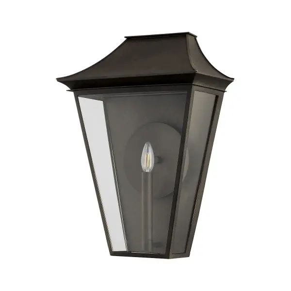 The Tehama wall sconce combines architectural design with functional illumination. Its reflector-enhanced candle design and clear glass panels maximize light output, while the angular frame and distinctive roof create visual interest.