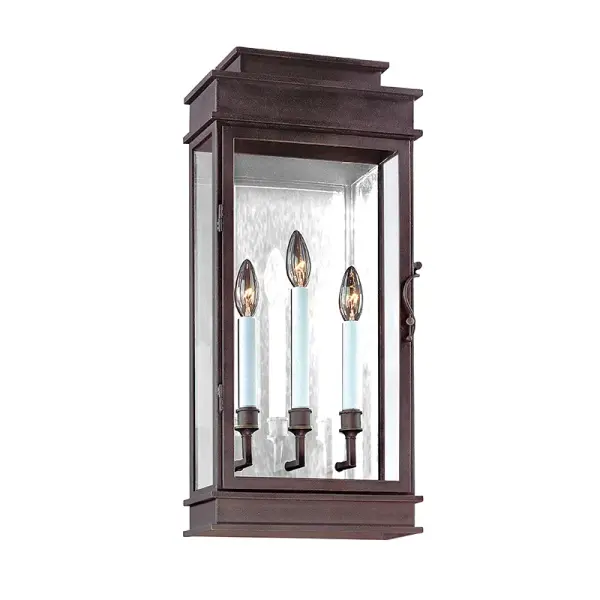 This three-light wall lantern combines traditional craftsmanship with practical outdoor durability. Hand-forged iron construction and clear glass panels create authentic vintage character while wet-rated certification ensures reliable performance in exposed locations.