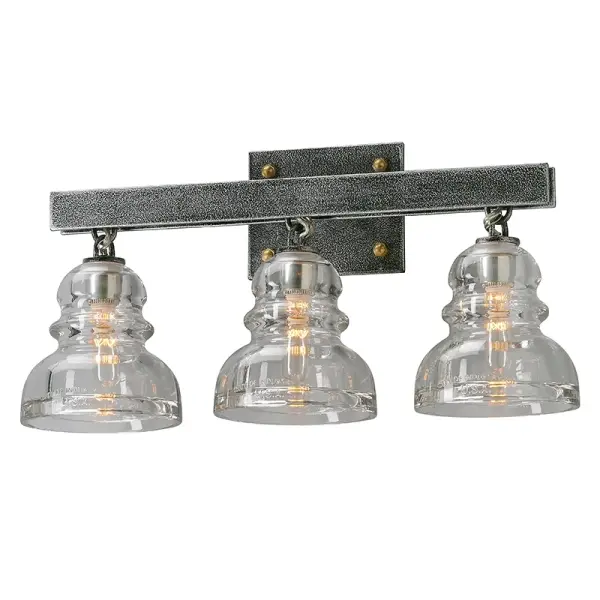The Menlo Park vanity light brings industrial charm to bathroom spaces with hand-worked iron construction and clear glass shades. Its 20.5-inch width makes it ideal for medium vanities, while the Old Silver finish adds vintage character.