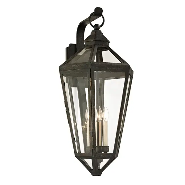 The Calabasas wall lantern brings old-world elegance to exterior spaces with hand-worked iron construction and a vintage bronze finish. Its substantial 33-inch height and clear glass panels create dramatic lighting.