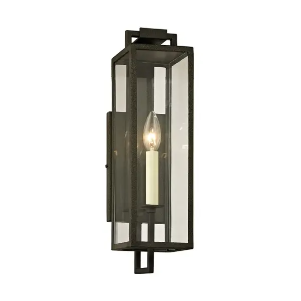The Beckham wall lantern combines old-world charm with sleek geometry, featuring hand-worked iron in a forged finish and clear glass. Designed specifically for large-scale home exteriors with wet-rated durability.