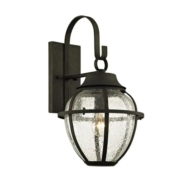 The Bunker Hill wall lantern combines traditional design with durable hand-worked iron construction. Its vintage bronze finish and clear glass panels create warm, welcoming illumination for exterior spaces.