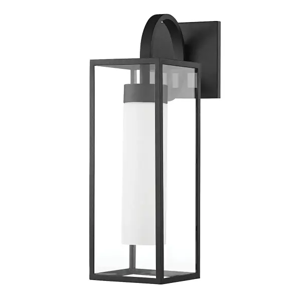The Pax outdoor wall sconce combines industrial aesthetics with a whimsical swooping arm design. Its textured black aluminum frame and elongated opal matte shade create striking visual contrast while providing reliable outdoor illumination.
