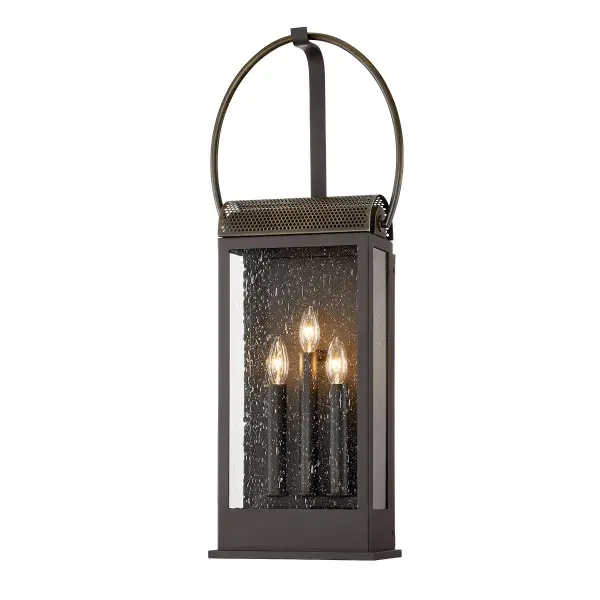 The Holmes three-light wall sconce combines traditional craftsmanship with wet-rated durability. Hand-crafted aluminum construction in Holmes Bronze finish paired with clear glass creates timeless appeal for exterior spaces.