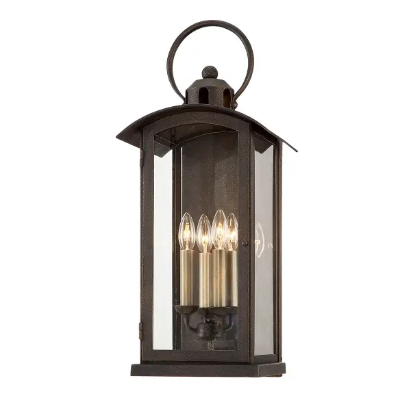 The Chaplin four-light wall sconce combines industrial charm with outdoor durability. Its hand-crafted aluminum construction and vintage bronze finish create an authentic aged look, while clear glass shades showcase candelabra bulbs for warm ambiance.