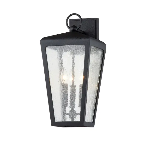The Mariden wall sconce combines hand-crafted aluminum construction with clear seeded glass for a rugged, industrial aesthetic. Its wet-rated design and substantial 20-inch height make it ideal for exterior applications.