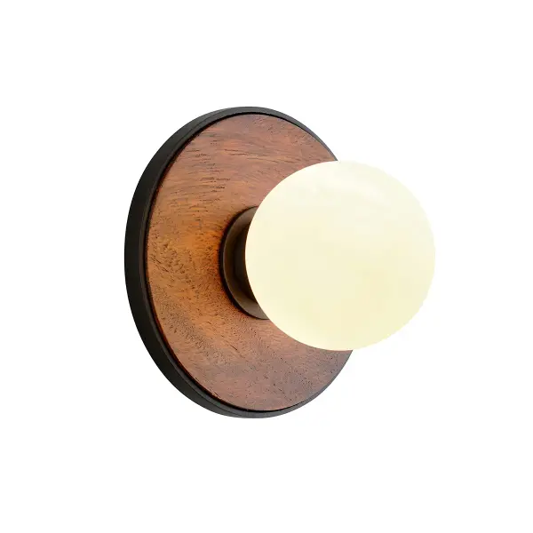 The Cadet wall sconce combines contemporary minimalism with artisanal craftsmanship. Its compact 6.5-inch cube design features hand-worked iron in soft black finish paired with opal glossy glass for warm, diffused light.