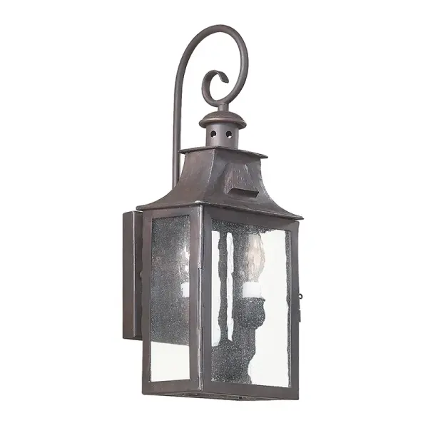 The Newton wall lantern combines traditional craftsmanship with modern durability. Hand-forged iron construction and clear seeded glass create timeless curb appeal, while wet-rated certification ensures reliable performance in any weather.