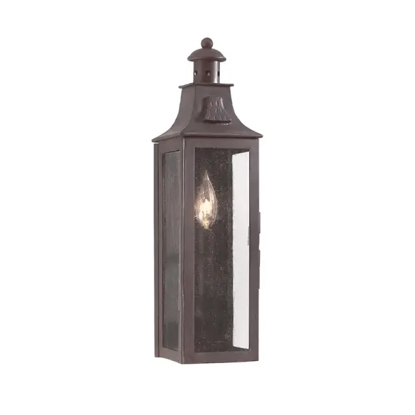 The Newton wall lantern combines traditional lantern styling with transitional appeal. Hand-forged iron construction and clear seeded glass create visual interest while the compact 5-inch width fits tight spaces.