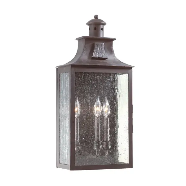 The Newton wall lantern combines traditional craftsmanship with versatile styling. Hand-forged iron construction and clear seeded glass create authentic character, while wet-rated certification ensures reliable outdoor performance.