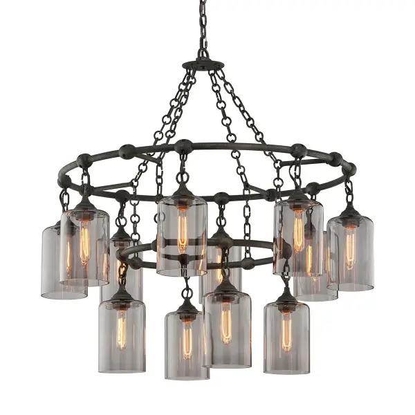 The Gotham 12-Light Chandelier commands attention with its substantial 38-inch frame and hand-worked iron construction. The aged pewter finish adds industrial sophistication while the painted glass shades soften the overall aesthetic.
