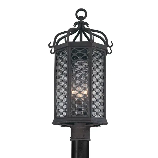 The Los Olivos post lantern brings Old World charm to outdoor spaces with hand-forged iron construction and clear seeded glass. Its wet-rated design and substantial build make it ideal for coastal and weather-exposed locations.