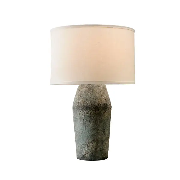 The Artifact table lamp brings an earthy, artisanal aesthetic with its shapely ceramic base in Moonstone finish and complementing linen shade. Its abstract form and textural surface create visual interest while maintaining versatility.