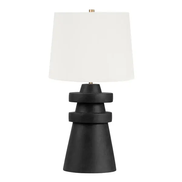 The Grover table lamp combines artisanal craftsmanship with contemporary design through its hand-crafted charcoal ceramic base featuring distinctive rings. The patina brass accents and off-white linen shade create sophisticated contrast.