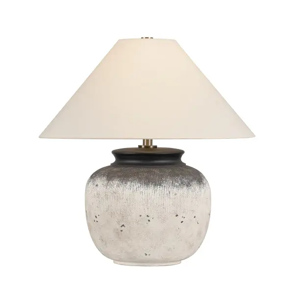 The Unearthed table lamp by designer Lauren Liess brings museum-quality artistry to residential spaces. Its hand-textured ceramic base mimics ancient pottery with gesso-like ridges and deliberate chipping, while Patina Brass accents and white linen shade balance rustic character with refined elegance.