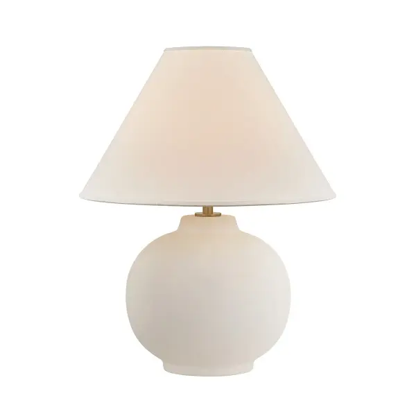 The Schubert table lamp combines a handcrafted ceramic base with a soft Sugar Cookie glaze and white linen drum shade for understated sophistication. Its tactile materiality and pure form create a calming presence in any space.