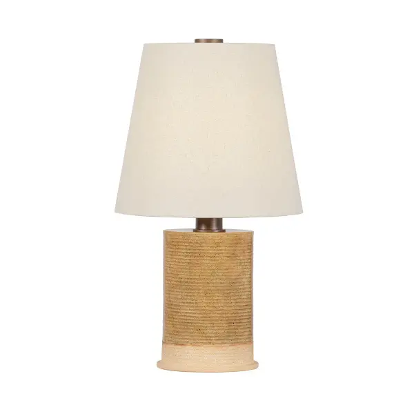The Kerwin table lamp showcases modern maker ceramics with its ribbed cylindrical form and warm Caramel Bisque glaze. Each piece is uniquely handcrafted with textural detail, topped with a natural linen shade and Bronze Leaf hardware for sophisticated artisanal appeal.