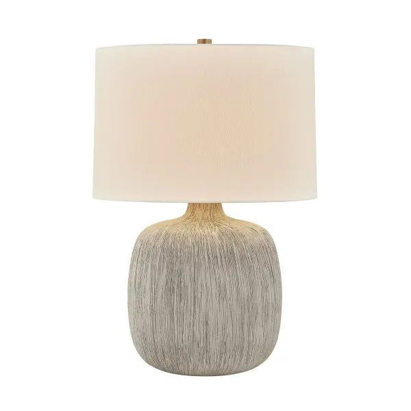 The Keagan table lamp combines organic form with refined materials. Its hand-glazed ceramic base in Stria Wheat finish offers unique textural interest, while the off-white linen shade and patina brass accents create a sophisticated, tonal palette.
