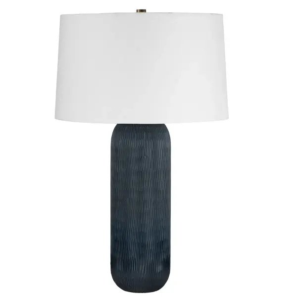 The Hopkins table lamp showcases Indian cut glass artistry with a striking gray-blue ombre that deepens toward the base. Hand-etched details add textural depth, while the white linen shade keeps focus on the sculptural glass. Each piece is unique.