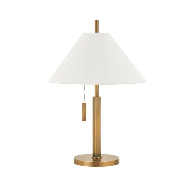 The Clic table lamp by designer Colin King combines clean geometric forms with refined materials. Its square brass body and circular base create visual interest, while the tapered off-white linen shade softens the look. The patina brass finish adds warmth and character.