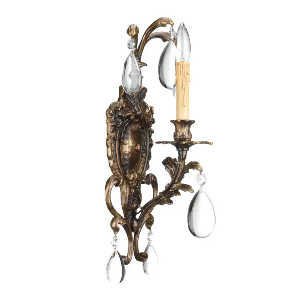This handcrafted Italian wall sconce combines traditional design with luxurious clear crystals and an antique bronze patina finish. Perfect for adding sophisticated ambient lighting to intimate spaces.