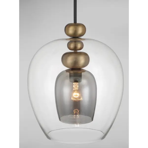 The Amesbury pendant combines industrial charm with modern sophistication through its unique coal and oxidized aged brass finish. The smoked gray glass shade adds depth while providing warm, diffused light perfect for intimate spaces. - alternate view